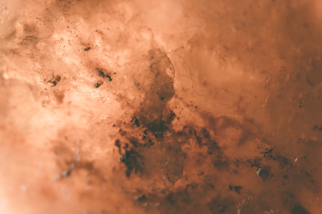 A close-up of premium Himalayan Pink salt crystals in a glass bowl showing various shades of pink and orange